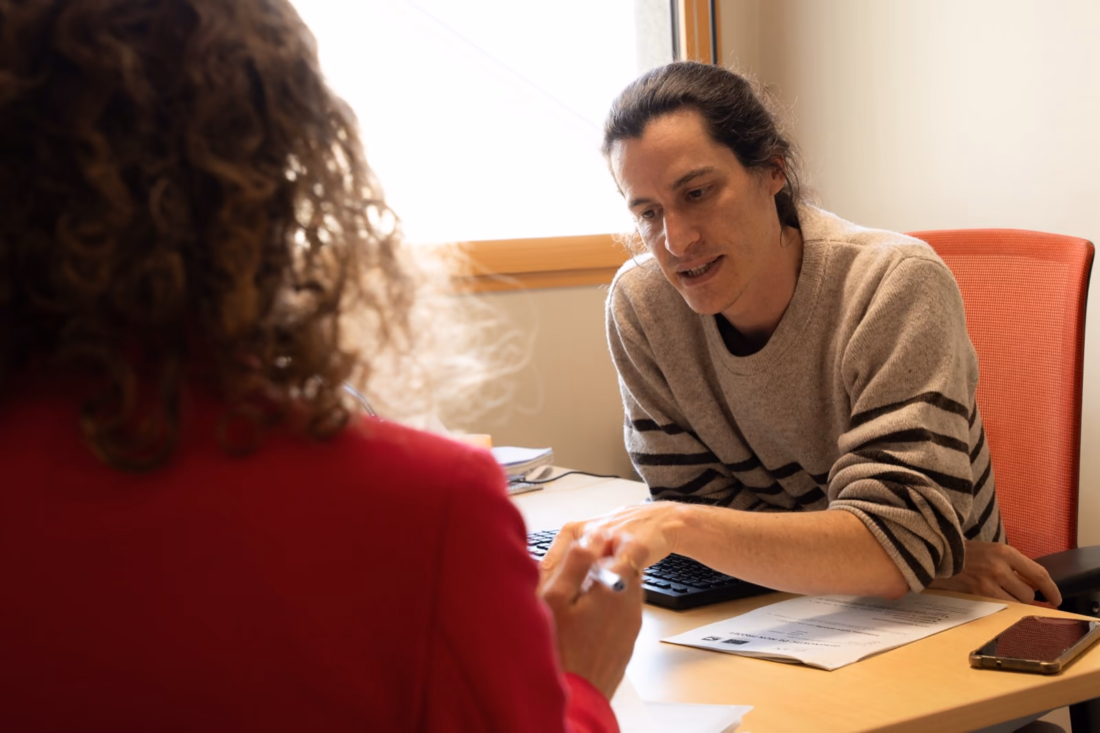 Une entrepreneure en rendez-vous avec un conseiller de l’équipe, devant un ordinateur.