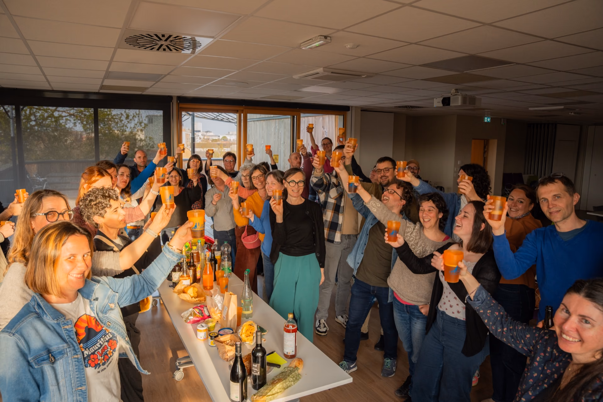 Les entrepreneures et entrepreneurs de la coopérative réunis autour d’un buffet, levant leur verre.